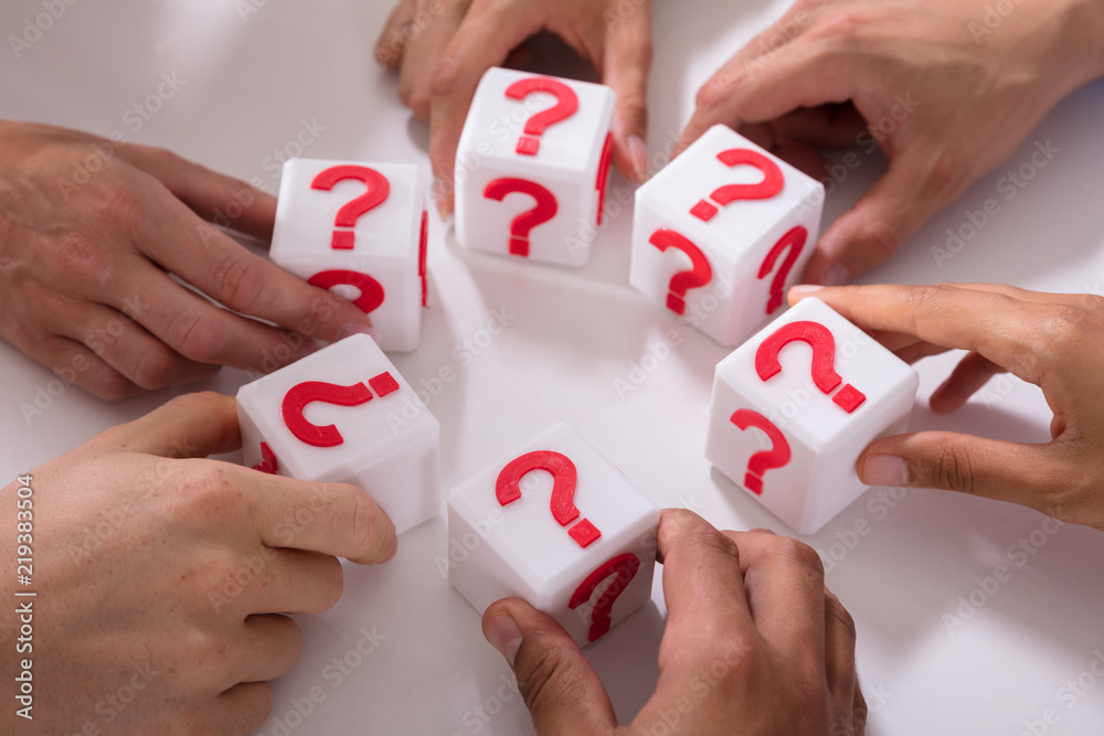 Businesspeople Holding Cubic Blocks With Question Mark Sign
