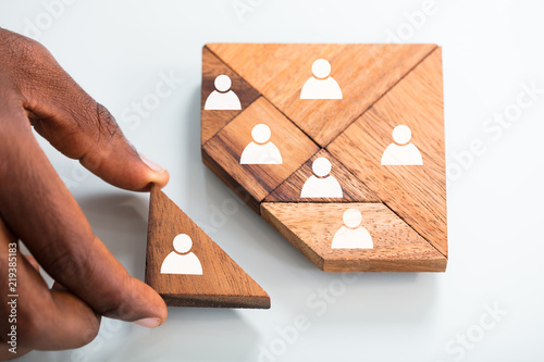 Person's Hand Completing Tangram Puzzle