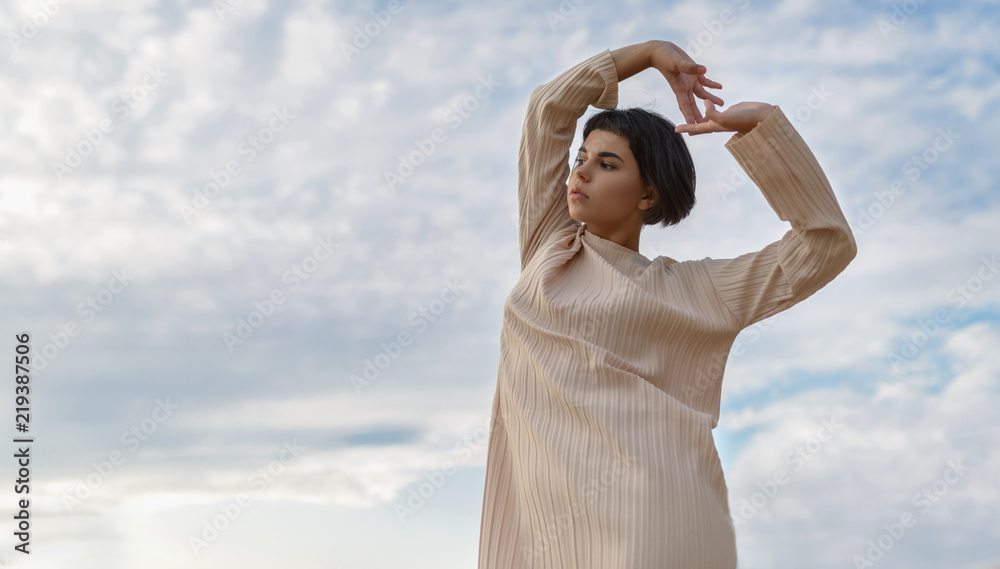 Portrait of a dancing woman over sky background. Portrait of a dancing woman over sky background.