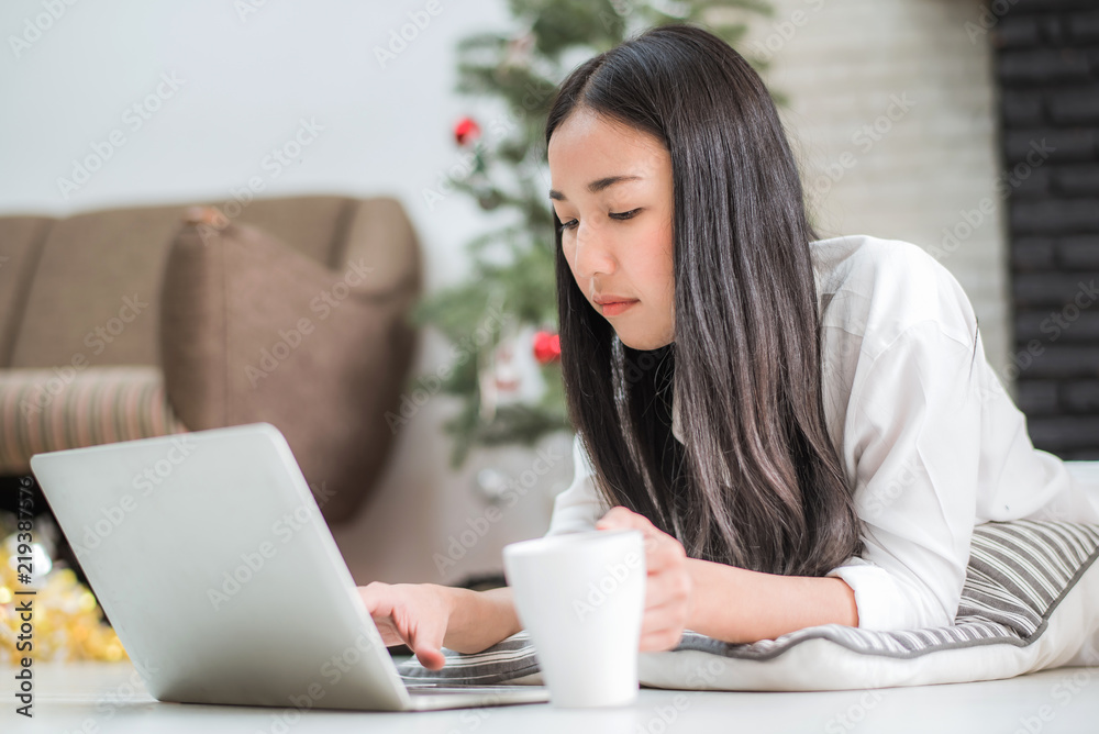 Happy young Asian business woman using laptop by laying on the floor at home, business online shopping. Happy young Asian business woman using laptop by laying on the floor at home, business online shopping.