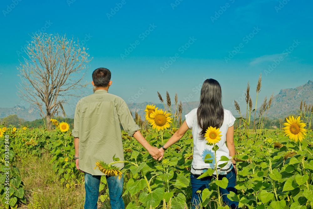 Obraz premium Couple of love in sunflower field