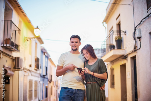Urban photo of young adult couple looking at cellphone