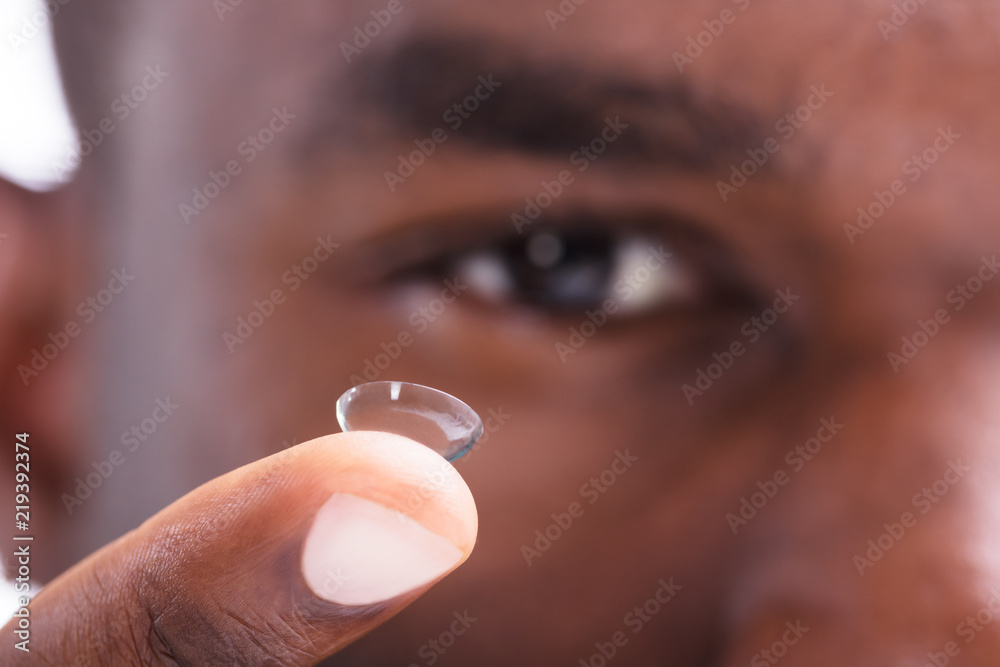 Fototapeta premium Man Holding Contact Lens In His Finger