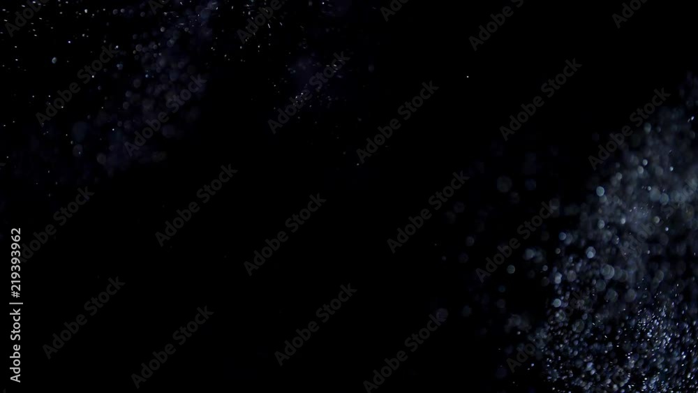 Floating particles on black background. Slow motion.
Floating particles on black background. Slow motion.
