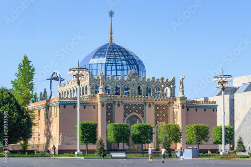 Pavilion Kazakhstan on Exhibition of Achievements of National Economy (VDNH) in Moscow against green trees and blue sky on a sunny summer morning photo