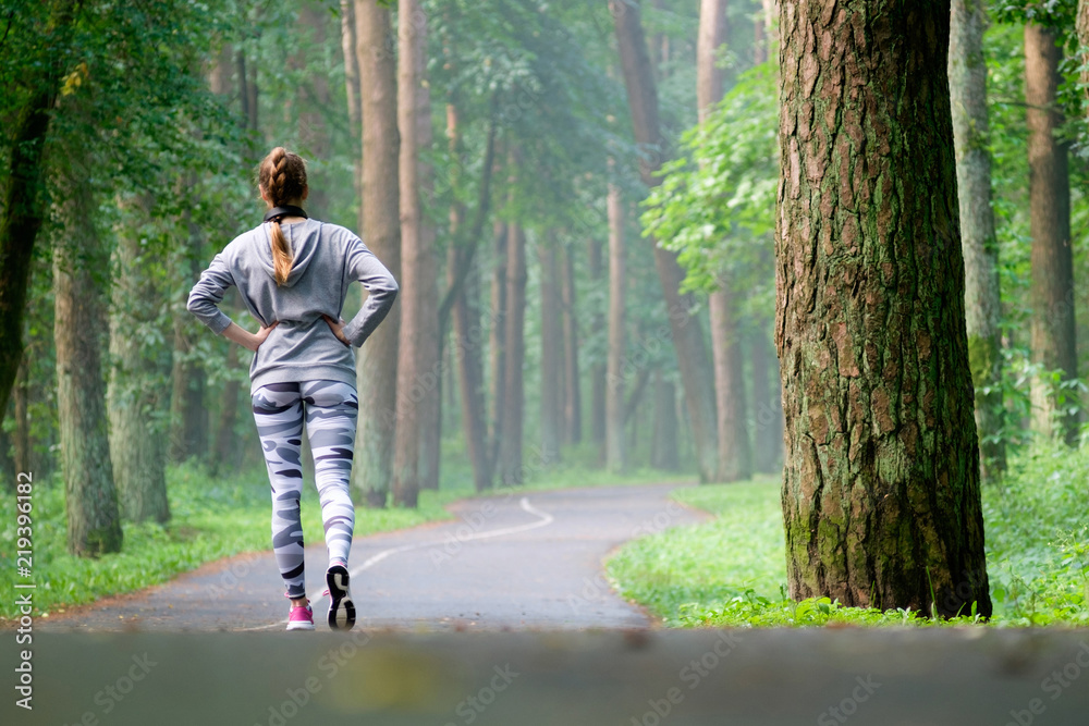 Beautiful attractive young woman stretching in the park and listen music Beautiful attractive young woman stretching in the park and listen music