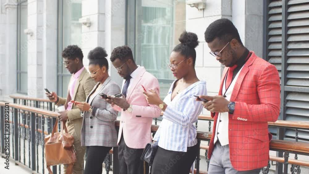 Five office workers standing with mobiles phones and typing sms to each other. business game. igromania concept. free wi-fi concept Five office workers standing with mobiles phones and typing sms to each other. business game. igromania concept. free wi-fi concept