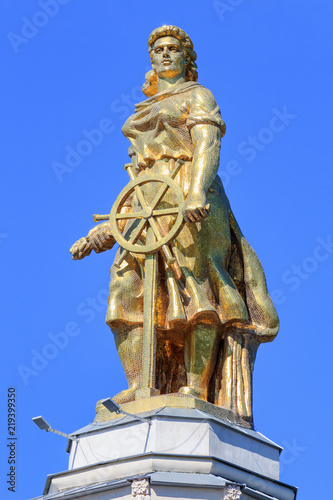 Figure of a woman of tractor driver against blu sky on a roof of pavilion Space on VDNH in Moscow on a sunny summer morning