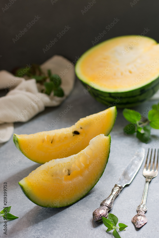 Two pieces of watermelon, a kitchen towel and a knife Two pieces of watermelon, a kitchen towel and a knife