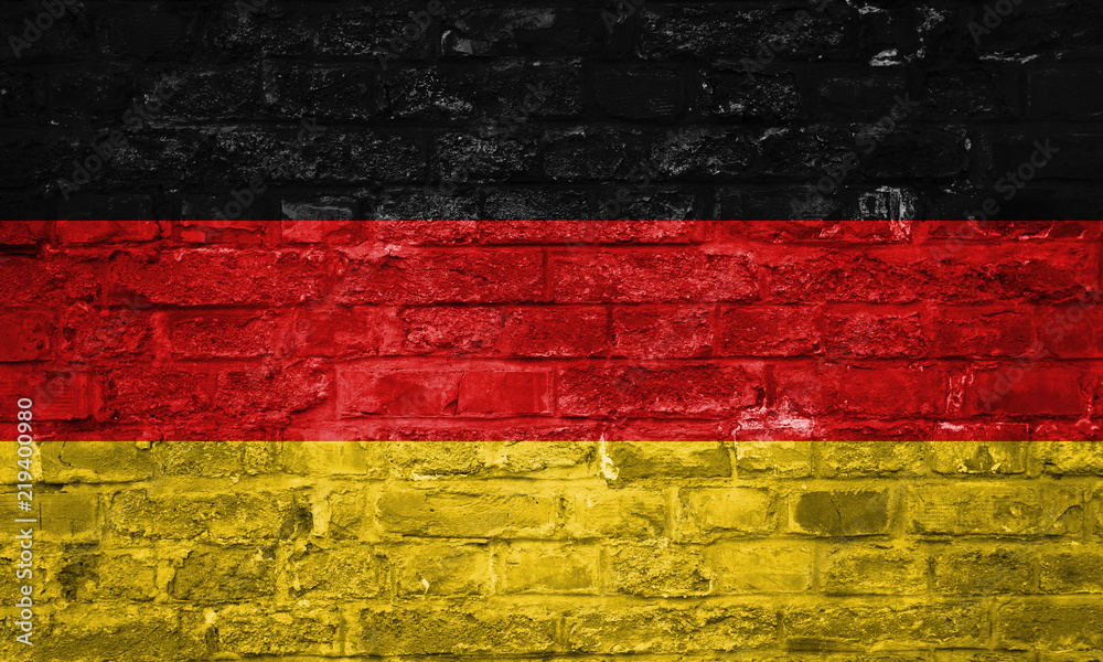 Flag of Germany over an old brick wall background, surface