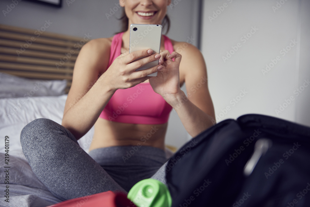 Female athlete using a mobile phone at home