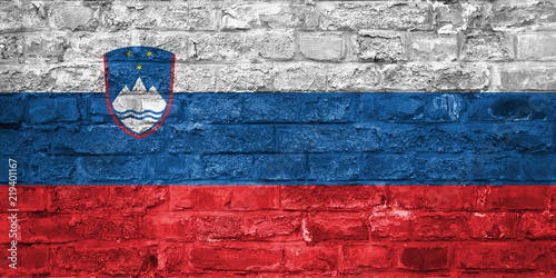 Flag of Slovenia over an old brick wall background, surface