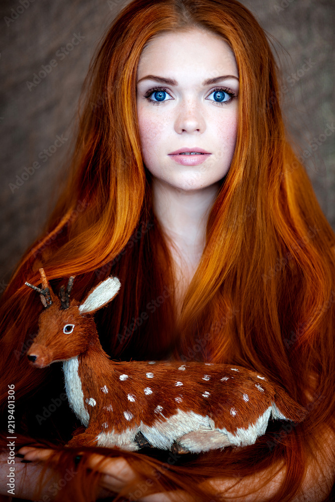 red-haired girl with gorgeous long hair and blue eyes with a toy fawn in  her hands Stock Photo | Adobe Stock