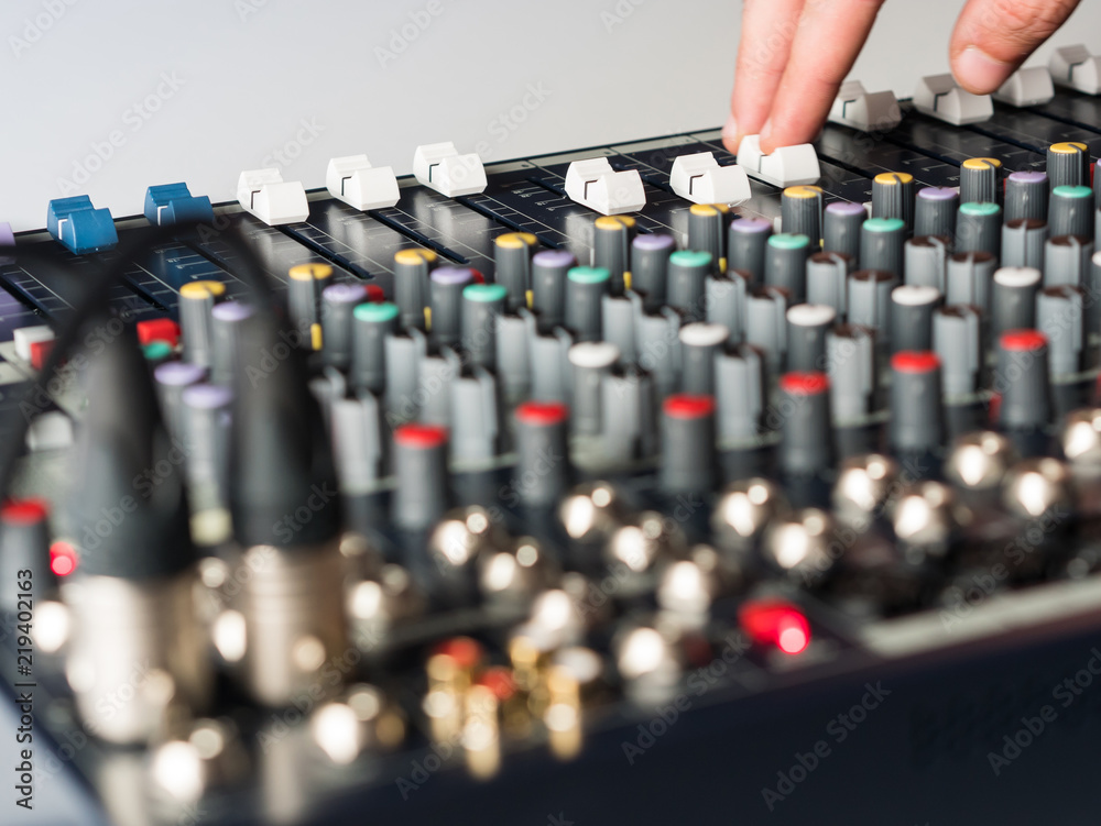 Obraz premium Dj adjsuting fade sliders on audio mixer