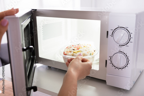 Fotografija Woman Heating Food In Microwave Oven