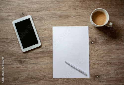 Flat lay with a cup of coffee white paper notebook tablet and white creditcard