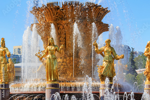 Gilded bronze girls against golden sheaf of wheat with technical hemp and sunflowers in fountain Friendship of peoples on VDNH in Moscow