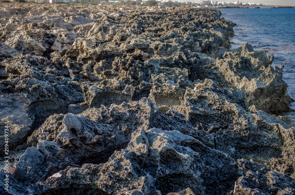 Rocky shore with sharp edges washed by the ocean Rocky shore with sharp edges washed by the ocean