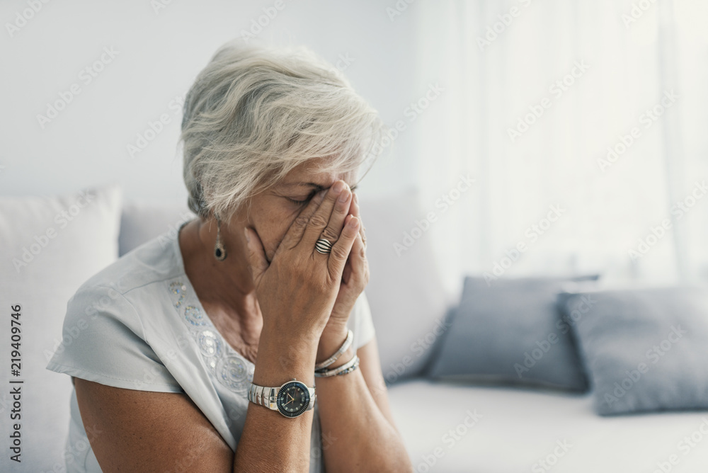 A solemn elderly woman sitting on her bed dealing with depression A solemn elderly woman sitting on her bed dealing with depression