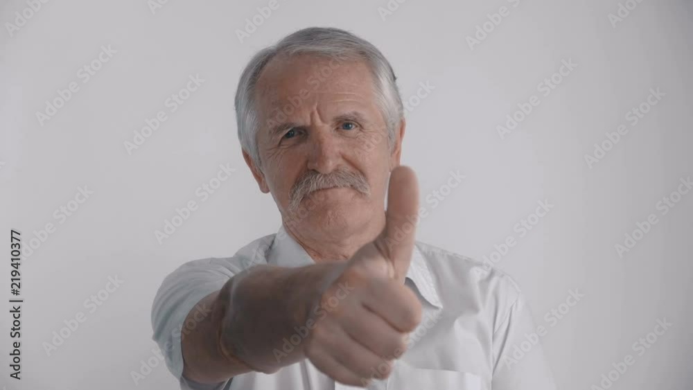 Gray-haired senior man showing his thumb up. Sign of approval Gray-haired senior man showing his thumb up. Sign of approval