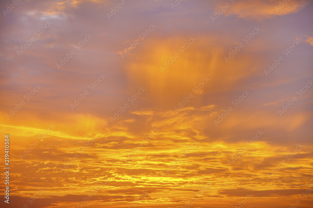 Sunset sky background. Dramatic sunset sky with evening sky clouds lit by bright sunlight - natural city sunset sky landscape view.
