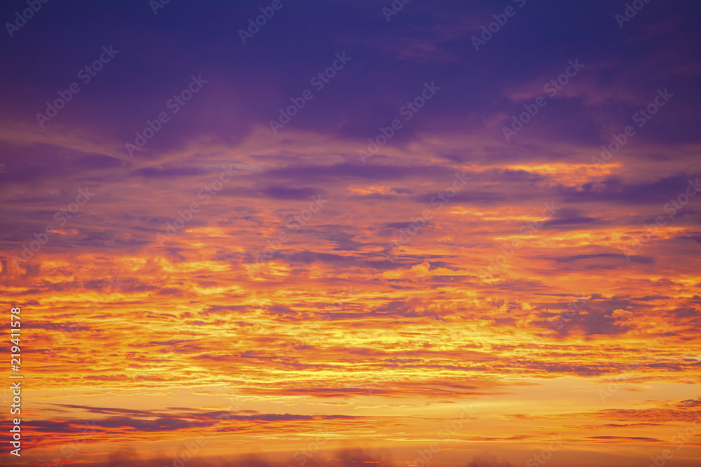 Sunset sky background. Dramatic sunset sky with evening sky clouds lit by bright sunlight - natural city sunset sky landscape view.
