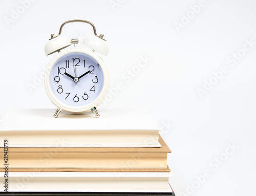 Alarm clock and books isolated on white background.