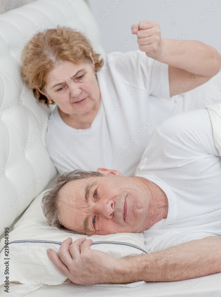 angry wife scolds her husband on the bed in the bedroom angry wife scolds her husband on the bed in the bedroom