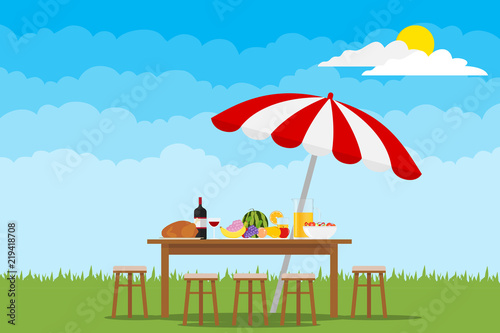 Picnic in nature. A table with food and chairs on green grass.