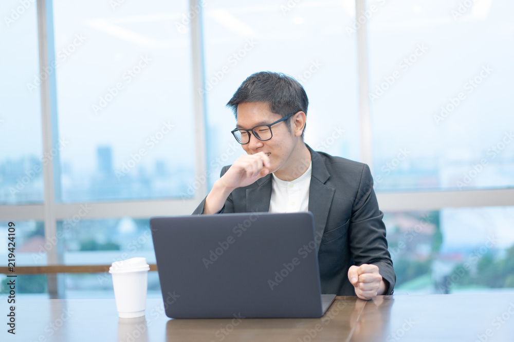 a happy businessman is working with his laptop computer. a happy businessman is working with his laptop computer.