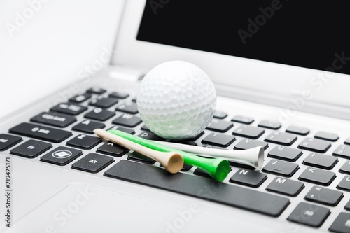 golf ball and some golf tees on a laptop computer