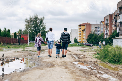 Mom with three children goes home on a bad road with holes © Мар'ян Філь