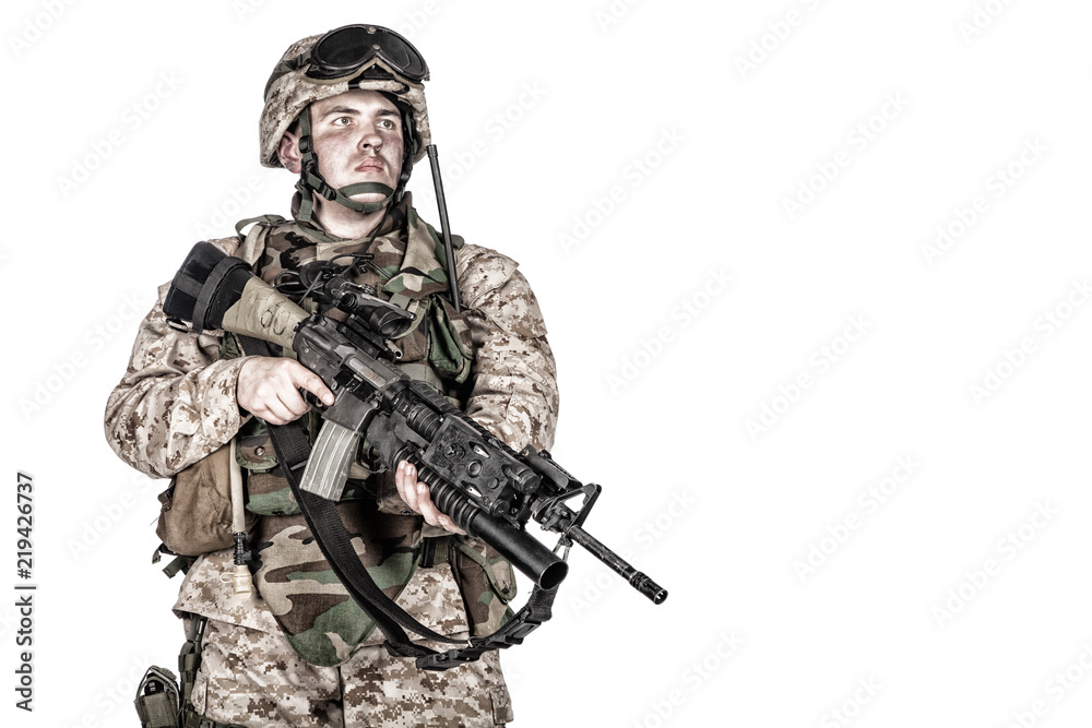 Studio shoot of marine infantry, commando soldier in full protective ammunition, standing with service rifle equipped grenade launcher and looking at camera, isolated on white background Studio shoot of marine infantry, commando soldier in full protective ammunition, standing with service rifle equipped grenade launcher and looking at camera, isolated on white background
