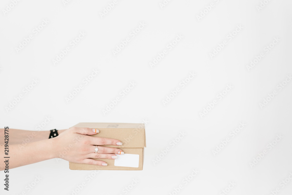Obraz premium shopping and goods delivery. woman hands holding a cardboard box. online stores and ordering on the internet concept.