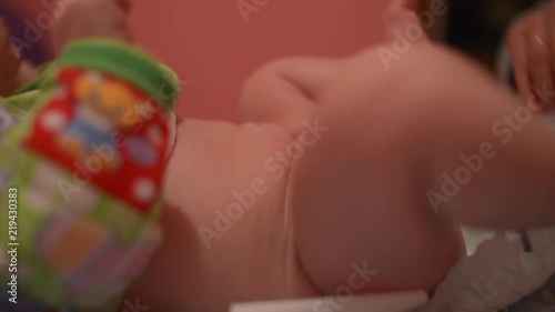Mom puts the diaper on the child