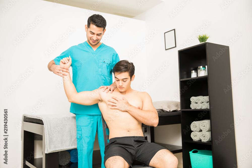 © AntonioDiaz - Physiotherapist Treating Shirtless Man Suffering From Shoulder Ache