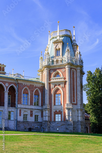 Tower of Great Palace in Museum-reserve Tsaritsyno in Moscow on a green lawn and blue sky background at sunny summer morning