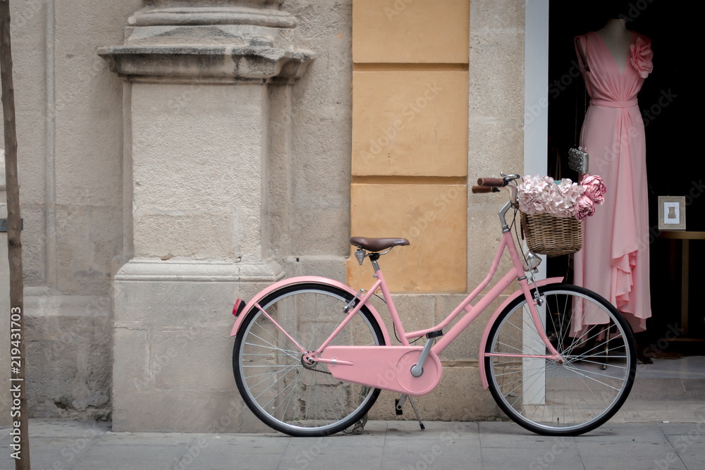Pink bicycle in front of a pink dress Pink bicycle in front of a pink dress