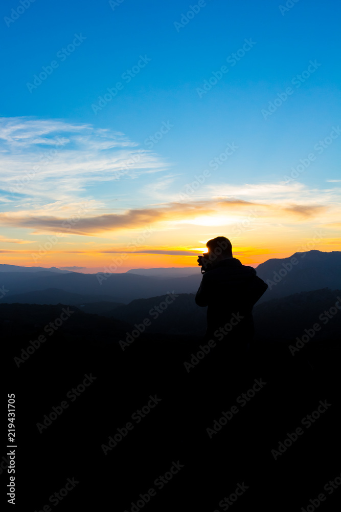 Man photographing the mountains at sunset