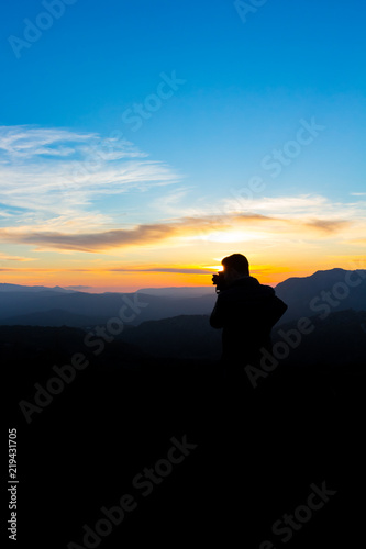 Man photographing the mountains at sunset