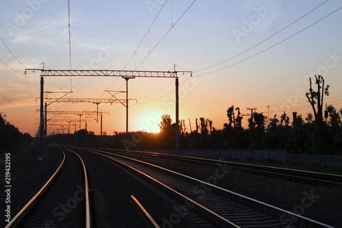 Railway tracks going in the direction of a beautiful sunset. The railroad, at sunset.