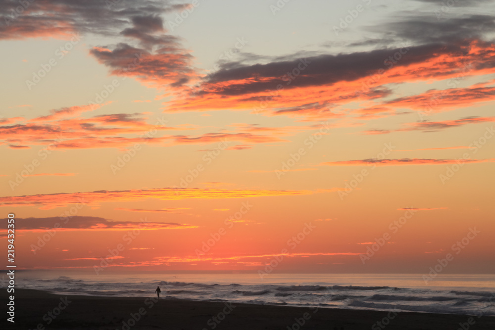 Man Walking on Pacific Ocean Beach at Dawn under a Dramatic Tropical Sky Man Walking on Pacific Ocean Beach at Dawn under a Dramatic Tropical Sky