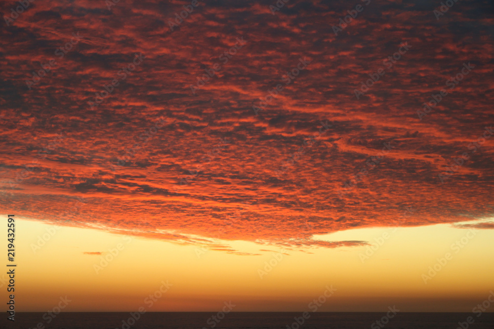 Dramatic Volcanic Crimson Sunset over Pacific Ocean