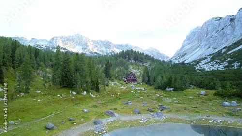 Aerial: Triglav national park in Slovenia, Seven lakes valley, lake cottage at height of 1685m. Beautiful valley with lakes between high mountains.