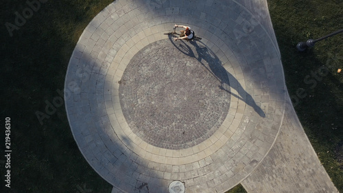 Top view bicycle woman riding a bike on round road in city park
