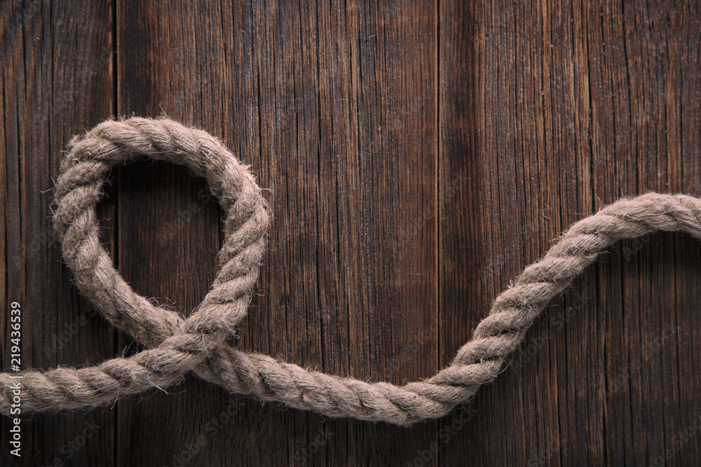 Thick twisted rope on a wooden background Thick twisted rope on a wooden background