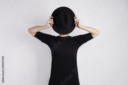 Woman in black hidden her face by black hat. Concept of metaphor, drama, hide emotion or personality.
