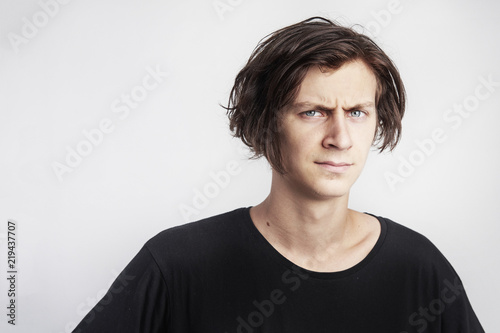 Portrait of young handsome hipster man look serious stressful, black t-shirt, white background..