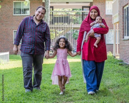 A family of four is walking away from their home