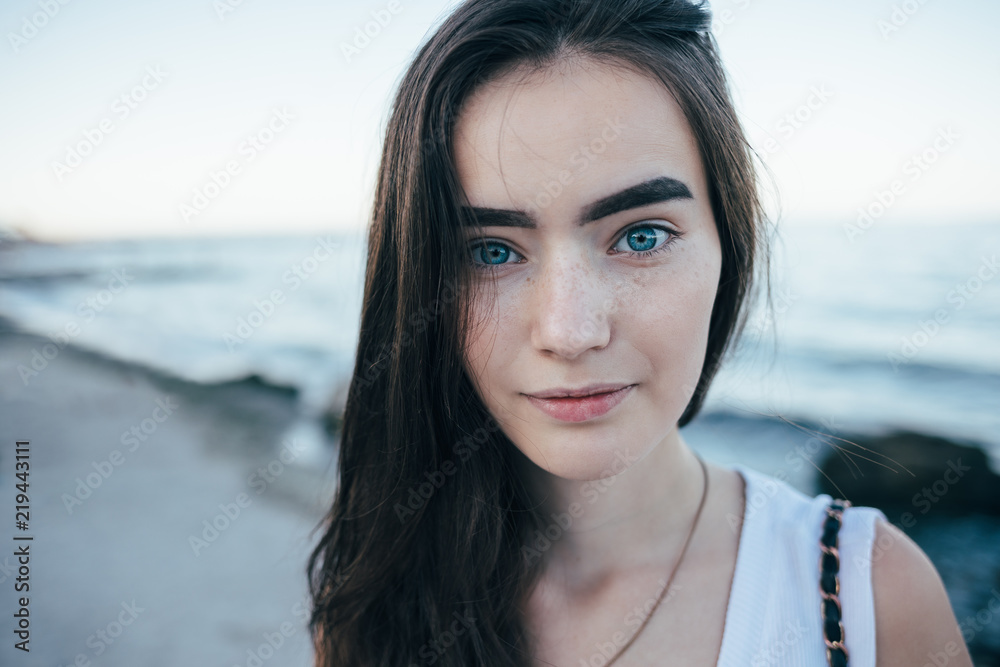 Candid portrait of beautiful young woman on the beach